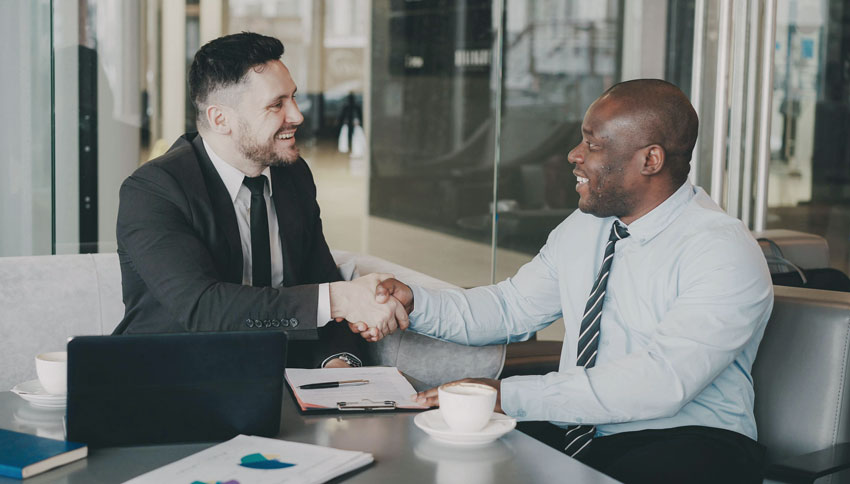 Two male business executives shaking hands